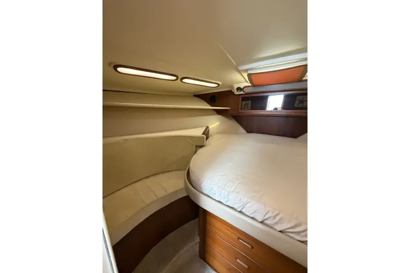 Slide: The Image of 1998 Luhrs 40 Open yacht cabin with cozy bed and wooden storage drawers. - 16