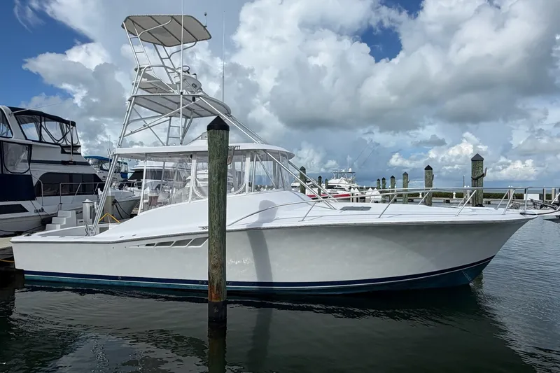 The Image of 1998 Luhrs 40 Open yacht docked at marina under cloudy sky. - 0