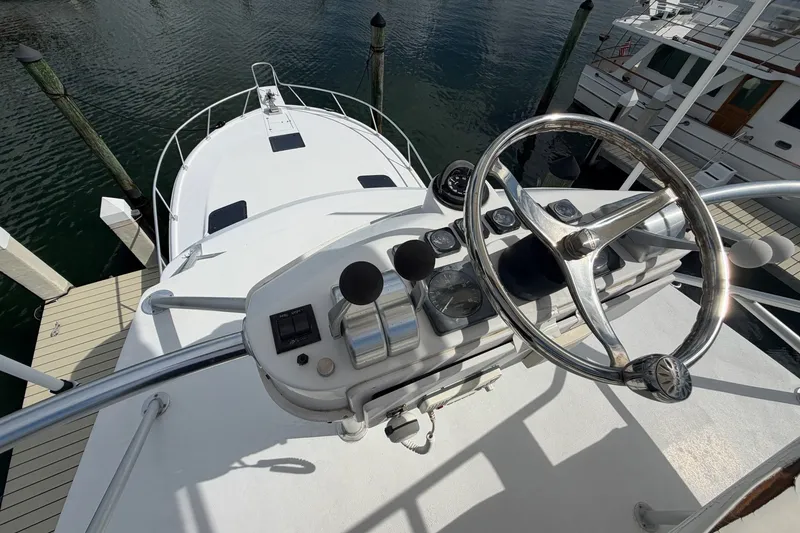Slide: The Image of 1998 Luhrs 40 Open yacht helm with steering wheel and controls, docked at marina. - 32