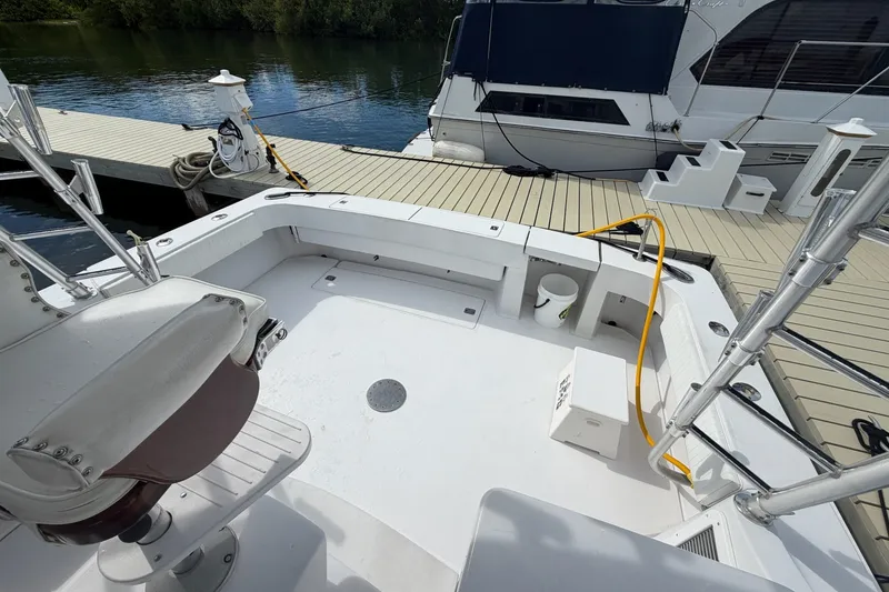 Slide: The Image of 1998 Luhrs 40 Open boat deck with seating, docked beside another vessel. - 21