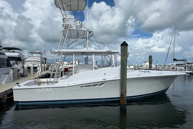 Slide: The Image of 1998 Luhrs 40 Open yacht docked at marina under cloudy sky. - 38