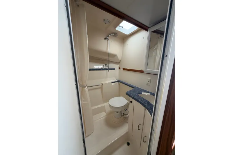 Slide: The Image of 1998 Luhrs 40 Open yacht bathroom with shower, toilet, and vanity. - 19