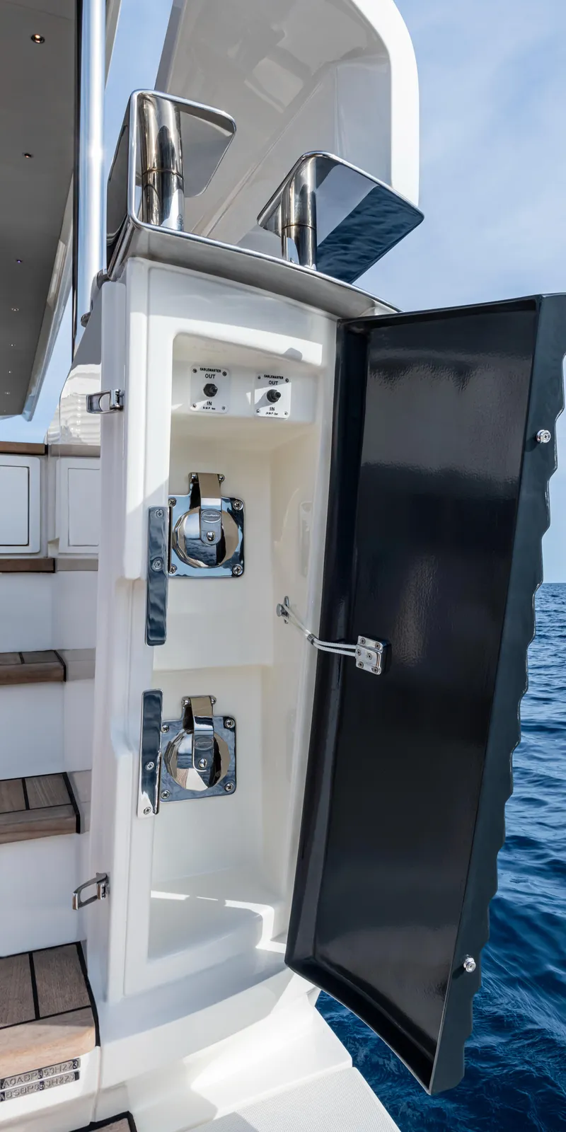 Slide: The Image of 2025 Absolute NAVETTA 75 yacht detail with open storage compartment by the sea. - 8