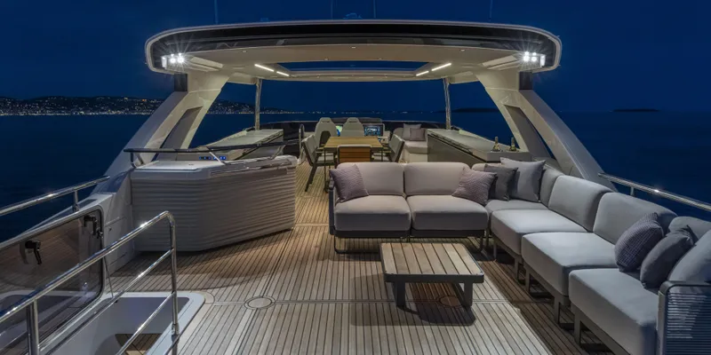 Slide: The Image of Luxurious 2025 Absolute NAVETTA 75 yacht deck at night, featuring elegant seating and ambient lighting. - 16