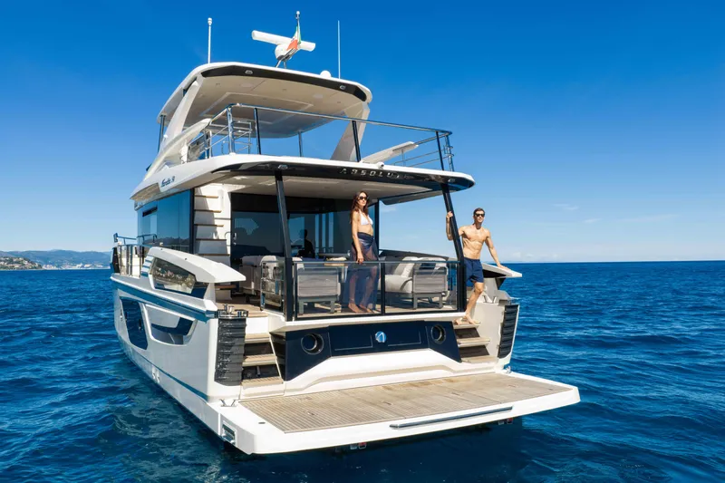 Slide: The Image of 2026 Absolute Navetta 58 yacht on open sea with two people enjoying the deck. - 4