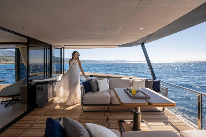 Slide: The Image of Luxurious Absolute Navetta 58 yacht deck with elegant woman, ocean view, and stylish seating, 2026 model. - 10