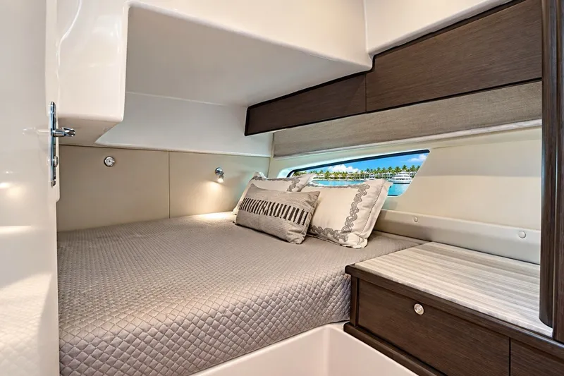 Slide: The Image of Luxurious cabin interior of 2022 Intrepid 477 Evolution yacht with elegant bedding and window view. - 11