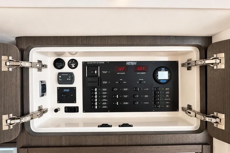 Slide: The Image of Electrical control panel of 2022 Intrepid 477 Evolution boat, featuring various switches and gauges. - 33