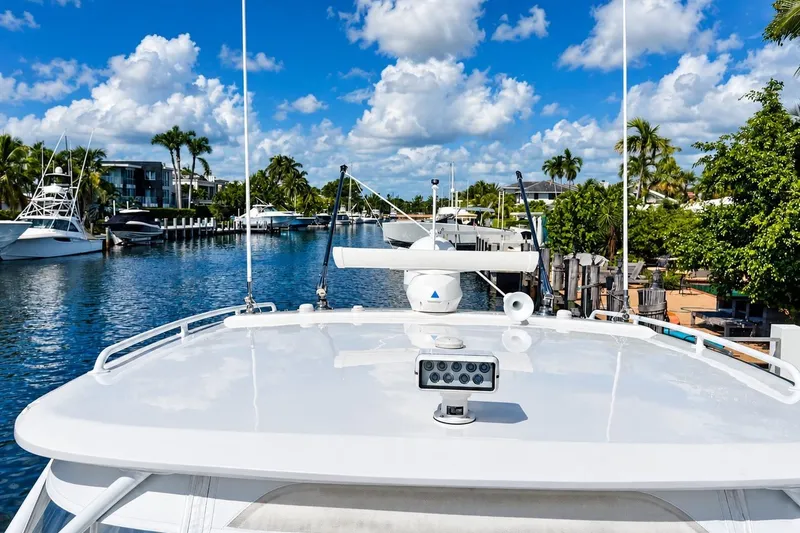 Slide: The Image of 2022 Intrepid 477 Evolution yacht docked in a scenic marina under a blue sky. - 8
