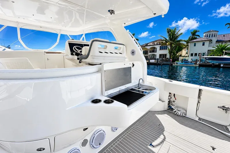 Slide: The Image of 2022 Intrepid 477 Evolution yacht interior with sleek design, featuring helm and outdoor kitchen. - 16