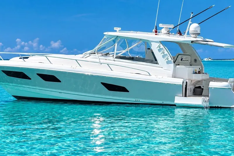 The Image of 2022 Intrepid 477 Evolution yacht on clear turquoise water under a bright blue sky. - 0