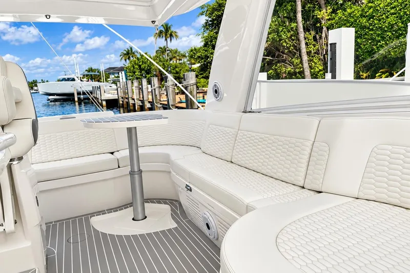 Slide: The Image of Luxurious seating area on 2022 Intrepid 477 Evolution yacht, docked by a scenic waterfront. - 29