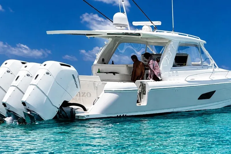 Slide: The Image of 2022 Intrepid 477 Evolution yacht on clear blue water with people onboard. - 1