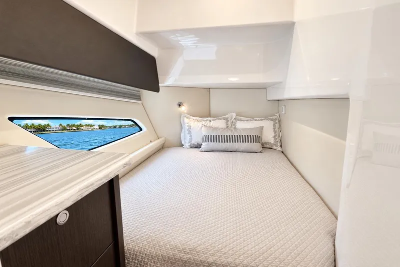 Slide: The Image of Luxurious cabin interior of 2022 Intrepid 477 Evolution yacht with elegant bedding and ocean view. - 37