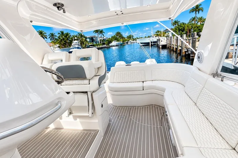 Slide: The Image of Luxurious interior of 2022 Intrepid 477 Evolution yacht with plush seating and scenic marina view. - 28