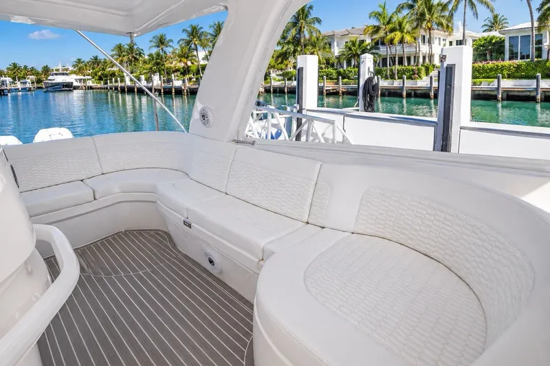 Slide: The Image of Luxurious seating area on 2022 Intrepid 477 Evolution yacht, docked by palm-lined waterfront. - 6