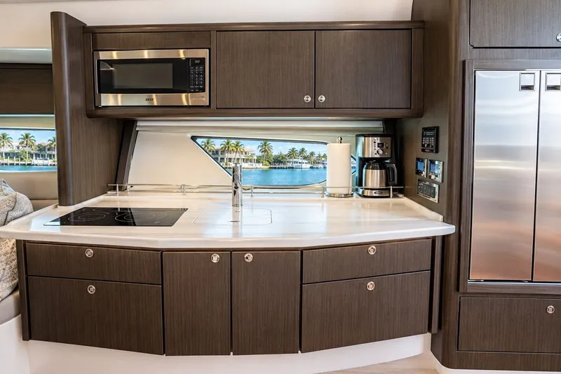 Slide: The Image of Modern kitchen interior on 2022 Intrepid 477 Evolution yacht, featuring sleek cabinetry and appliances. - 13