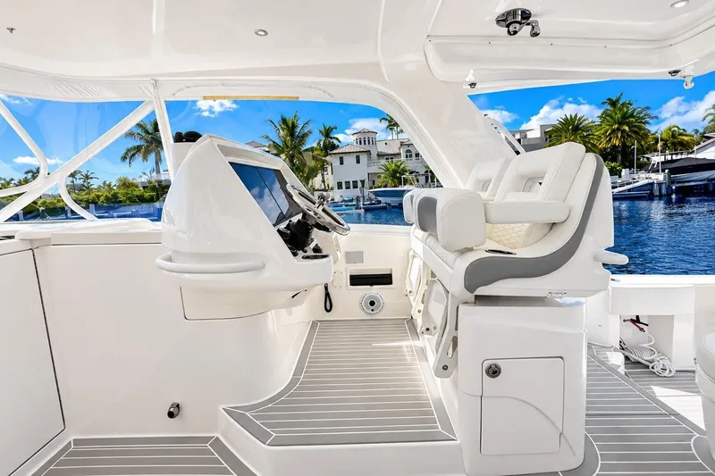 Slide: The Image of Luxurious 2022 Intrepid 477 Evolution yacht interior with helm and seating, overlooking marina. - 27