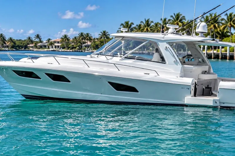 Slide: The Image of 2022 Intrepid 477 Evolution yacht on clear blue water with palm trees in background. - 2