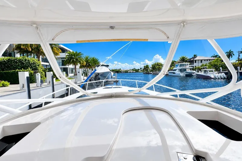 Slide: The Image of 2022 Intrepid 477 Evolution yacht docked in a scenic waterfront setting. - 30