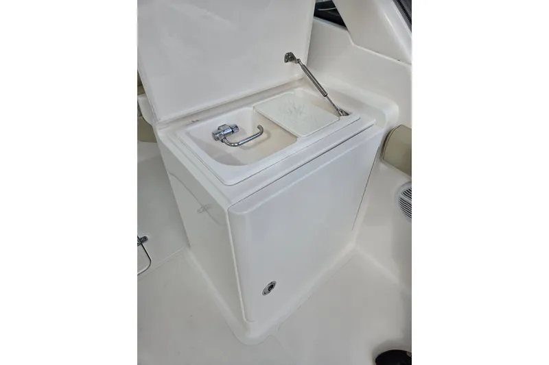 Slide: The Image of 2017 Pursuit DC 265 Dual Console boat sink with faucet and storage compartment. - 17