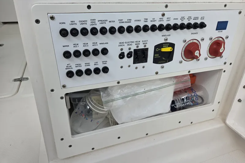 Slide: The Image of Control panel of a 2017 Pursuit DC 265 Dual Console boat with switches and storage. - 18