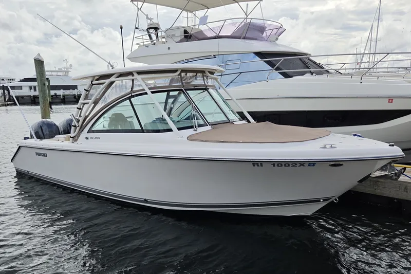 The Image of 2017 Pursuit DC 265 Dual Console boat docked at marina, side view. - 0