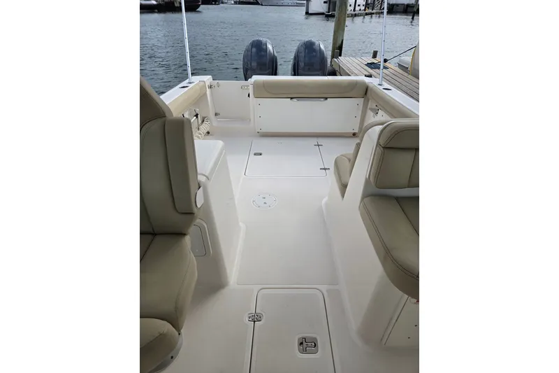 Slide: The Image of 2017 Pursuit DC 265 Dual Console boat interior with beige seating and spacious deck. - 13