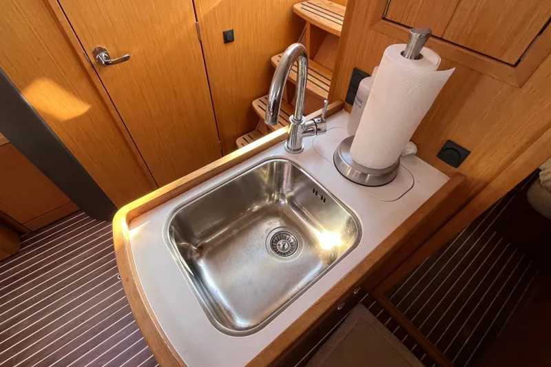 Slide: The Image of 2013 Bavaria Vision 46 yacht kitchen sink with wooden cabinetry and paper towel holder. - 21