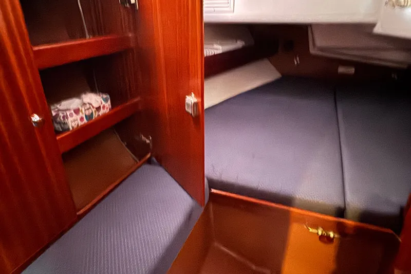 Slide: The Image of Interior cabin of 2003 Bavaria Cruiser 44 yacht with wooden shelves and blue bedding. - 27