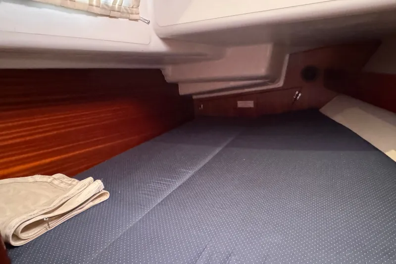 Slide: The Image of Cozy cabin interior of 2003 Bavaria Cruiser 44 yacht with wooden paneling and blue bedding. - 28