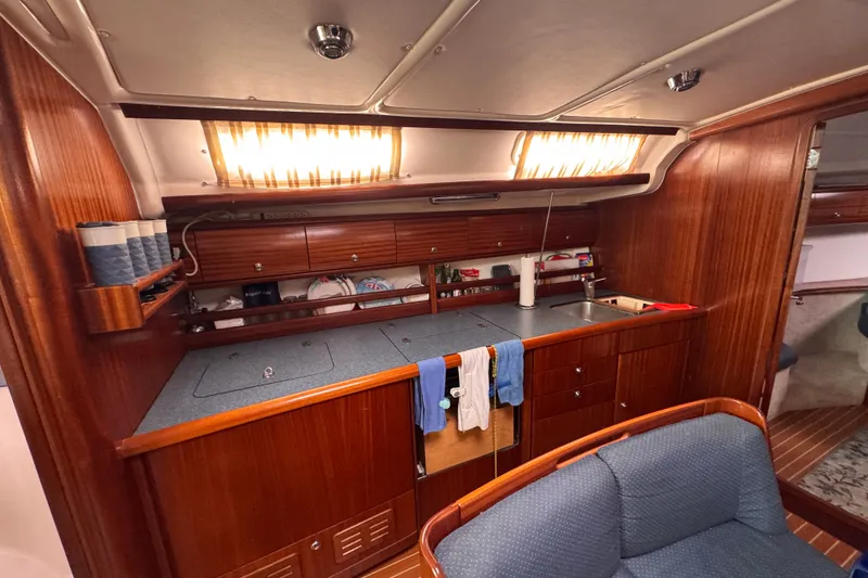 Slide: The Image of Interior of a 2003 Bavaria Cruiser 44 yacht kitchen with wooden cabinetry and modern amenities. - 19