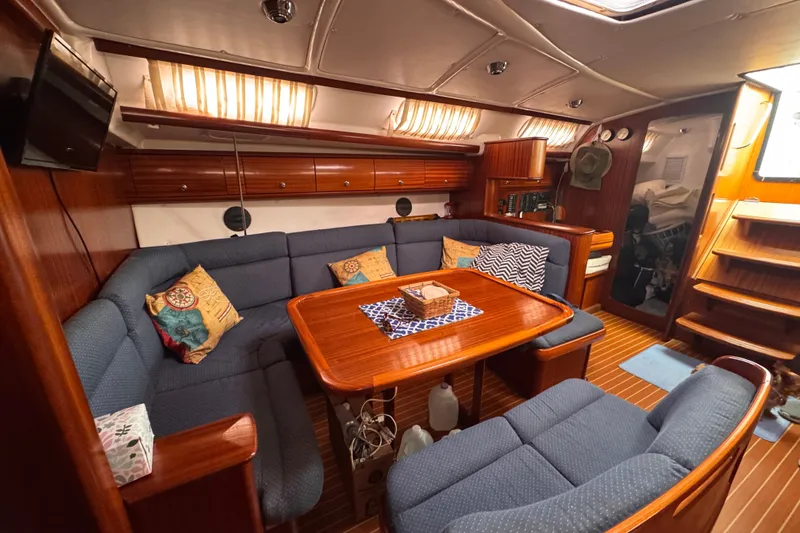 Slide: The Image of Cozy interior of 2003 Bavaria Cruiser 44 yacht with wooden dining area and blue seating. - 16