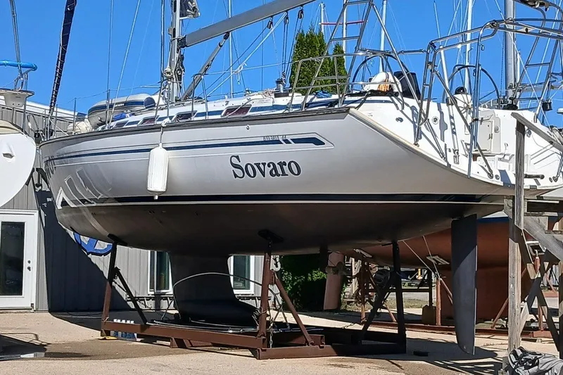Slide: The Image of 2003 Bavaria Cruiser 44 sailboat on dry dock, named Sovaro, under clear blue sky. - 37