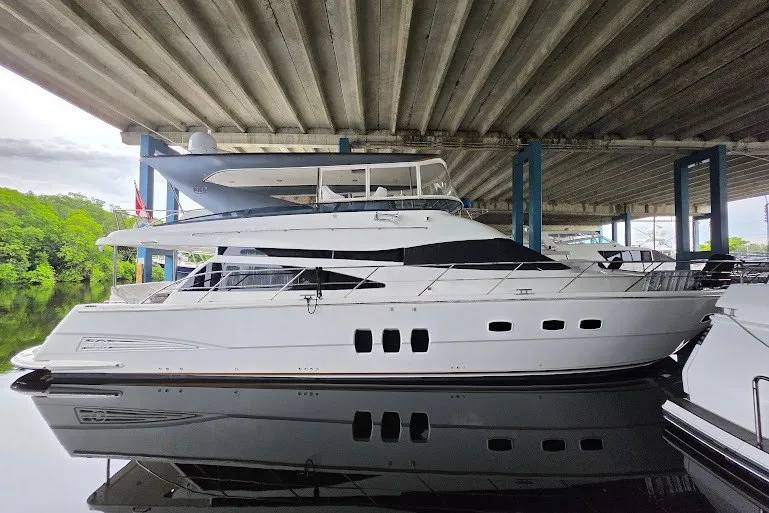Slide: The Image of 2008 Neptunus Flybridge MY yacht docked under a bridge, reflecting on calm water. - 1