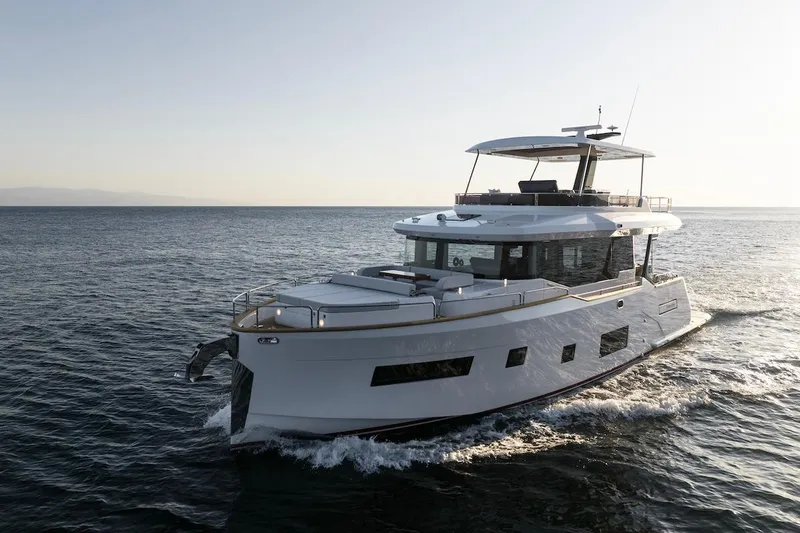 Slide: The Image of 2024 Sirena 58 Flybridge MY yacht cruising on open water at sunset. - 3