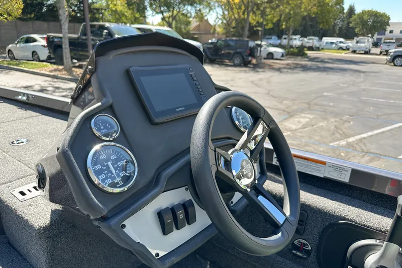 Slide: The Image of 2019 Ranger RT178 boat dashboard with steering wheel and digital display in a parking lot. - 6