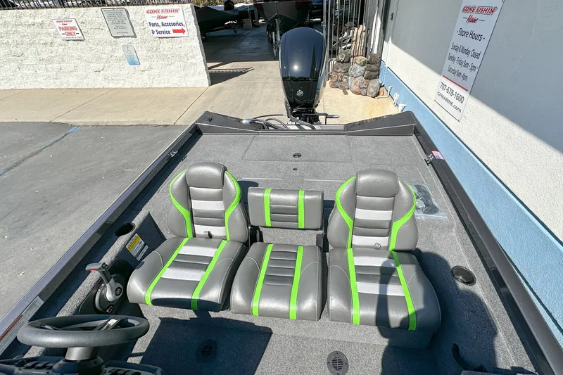Slide: The Image of 2019 Ranger RT178 boat interior with gray and green seats, parked outside a marine shop. - 9