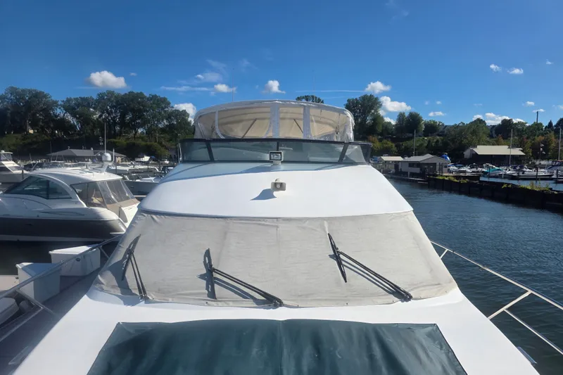 Slide: The Image of 2002 Neptunus 56 Flybridge yacht docked at a marina under a clear blue sky. - 4