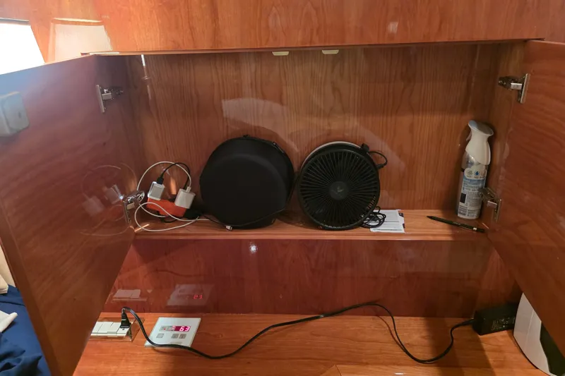 Slide: The Image of Wooden cabinet interior on a 2002 Neptunus 56 Flybridge yacht with electronics and air freshener. - 67