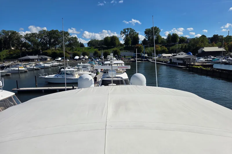 Slide: The Image of 2002 Neptunus 56 Flybridge yacht docked at a marina under a clear blue sky. - 8