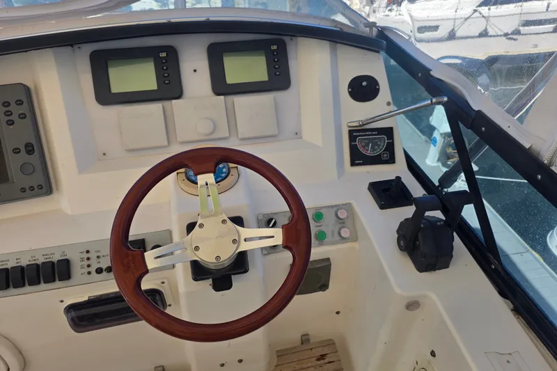 Slide: The Image of Helm of 2002 Neptunus 56 Flybridge yacht with wooden steering wheel and control panels. - 10