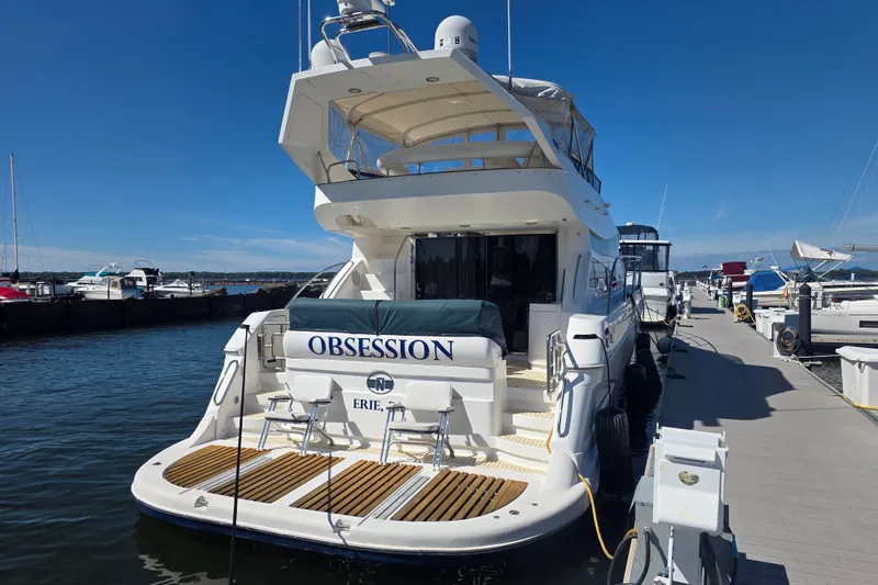 Slide: The Image of Luxury Neptunus 56 Flybridge yacht docked at marina, 2002 model, sunny day. - 2