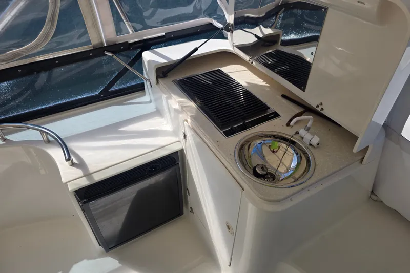 Slide: The Image of 2002 Neptunus 56 Flybridge yacht kitchen with sink, grill, and mini fridge. - 13