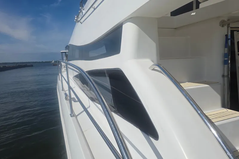 Slide: The Image of Side view of a 2002 Neptunus 56 Flybridge yacht with sleek design and chrome railings. - 3