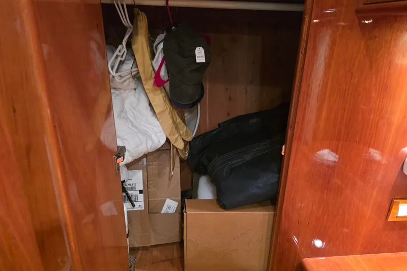 Slide: The Image of Storage closet on 2002 Neptunus 56 Flybridge yacht with boxes and clothing items. - 82