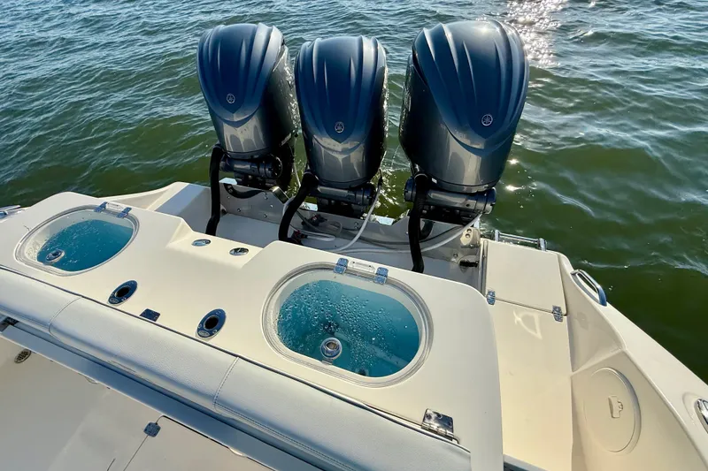 Slide: The Image of 2023 Cobia 350 Center Console with triple outboard engines on water. - 16