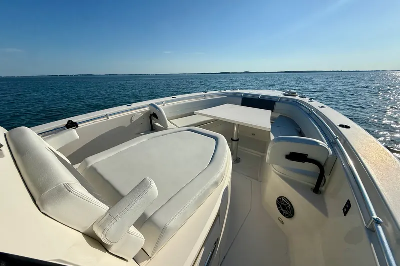 Slide: The Image of 2023 Cobia 350 Center Console boat interior with seating and table on open water. - 24