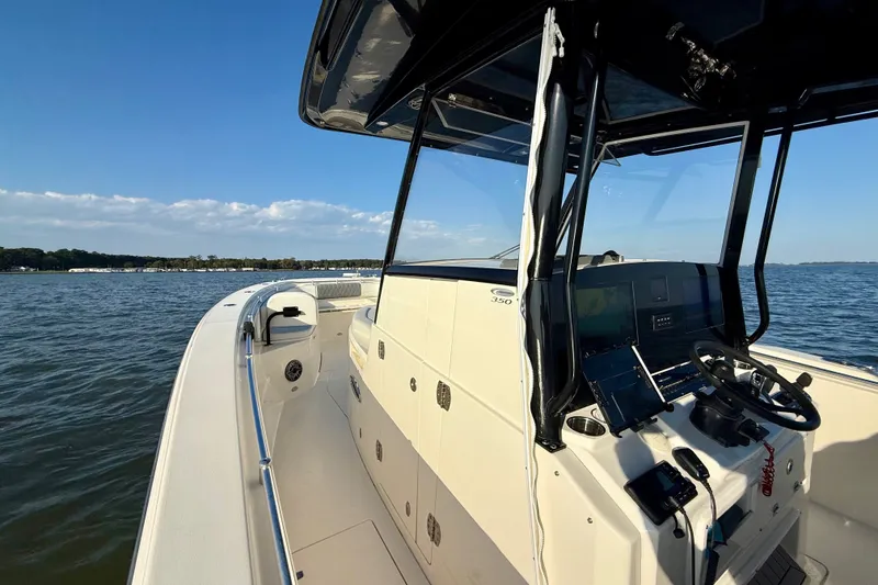Slide: The Image of 2023 Cobia 350 Center Console boat on open water, featuring modern helm and controls. - 19