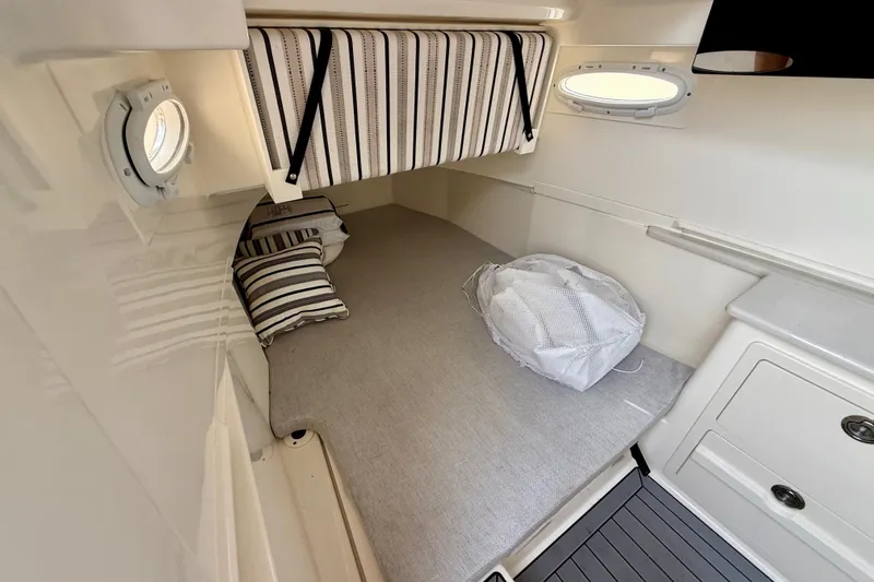 Slide: The Image of 2023 Cobia 350 Center Console cabin interior with striped cushions and portholes. - 29